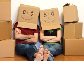 Happy couple in their new home having fun - moving concept